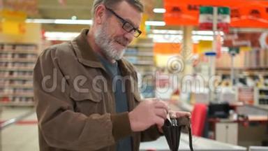 一位在超市里手里拿着钱包的老人的肖像。 养老金领取者微笑